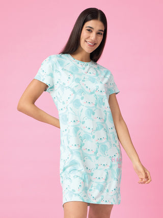 A woman smiles while posing in a light blue sleep dress with a repeating white and pink koala print.