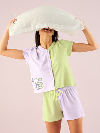 a women hold pillow on head and weared lily  half sleeve front open shorts