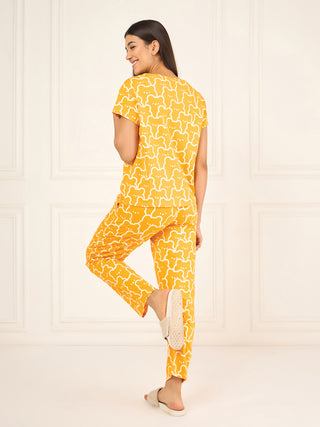 Women's yellow pajama set with a white bear print, model is standing on one leg.