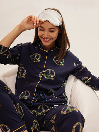 a girl smiling sitting on chair wearing navy colour front open pyjama set