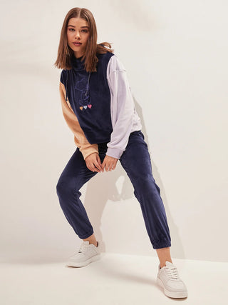a girl standing wearing navy colour round neck track suit