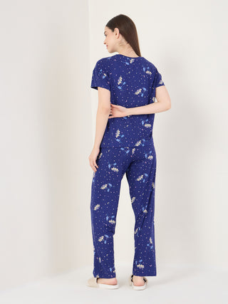 Women, seen from behind, wearing a navy blue pajama set with a celestial floral print.