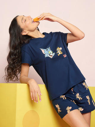 A woman in navy blue Tom and Jerry printed sleepwear, posing with a slice of cheese.