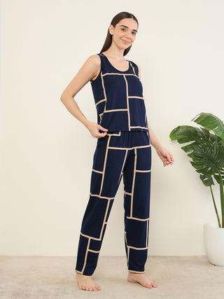 Women in a navy blue, geometric print, sleeveless pajama set, posing with her hand on her hip.