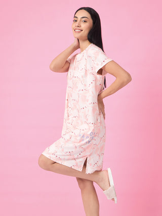 A woman poses playfully in a light pink, short-sleeved sleep dress with a scattered bunny print, featuring the text "OH HAPPY DAY" on the skirt.