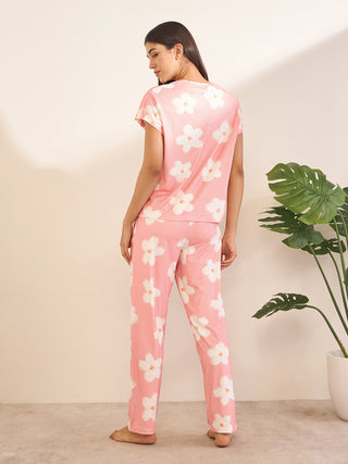 Women's pink pajama set with white floral print, shown from the back.