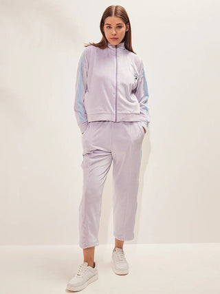 a girl standing wearing purple heather color track suit