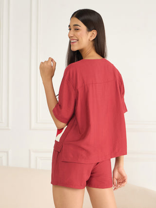 Women in a ruby red linen pajama set, featuring a cropped top and shorts with a crochet accent.