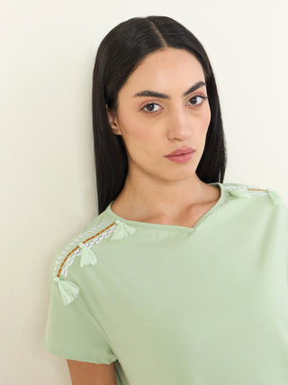 Women's pale green t-shirt with tassel and embroidered shoulder detail.