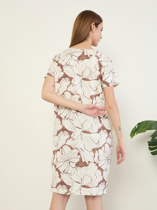 Women's cream floral print short-sleeve midi dress, facing away from the camera with her hands behind her back.
