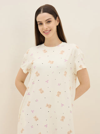 Women in a light-colored, short-sleeved nightgown featuring a playful print of teddy bears and bows.
