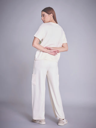 Women wearing off-white relaxed-fit top and wide-leg pants with cargo pockets.