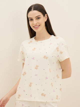 Women's cream pajama set with a teddy bear and flower print.