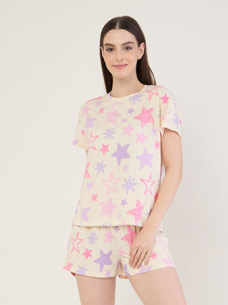 Women in a pale yellow star-print pajama set, posing with a slight smile.
