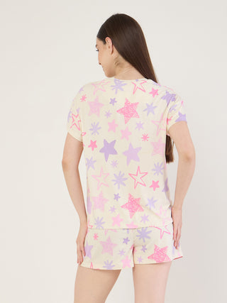Women's sleepwear set, seen from the back, with a light yellow background and a playful print of pink and purple stars.