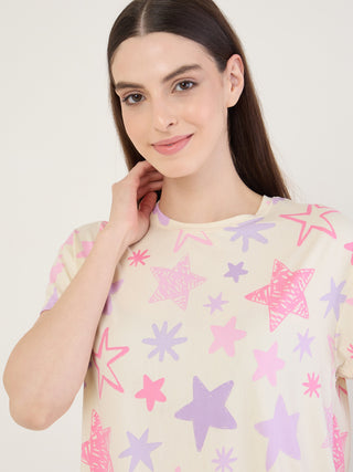 Women in a cream, star-print sleep shirt posing with a hand on their neck.