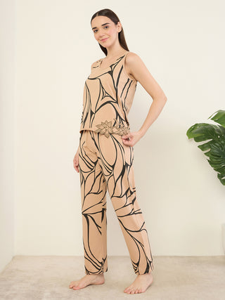 Women in a tan sleepwear set with a black abstract print and floral embroidery, standing and posing.
