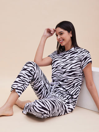 a woman setting on ground a support of white box wearing amour purple pyjama