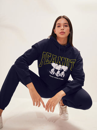 a woman smiling and wearing a navy color round neck track suit with hood
