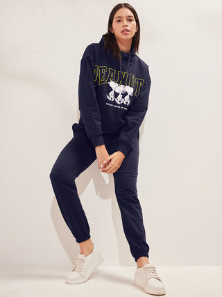 a woman wearing navy color round neck nightsuit and seating on couch