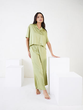 a girl stand in white background and weared aloe vera green front open half sleeve pyjama set 