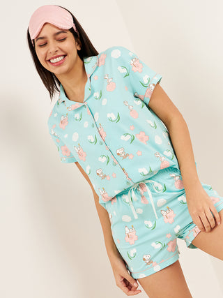 a woman smiling and standing wearing an aqua splash front open half sleeve Bermuda set
