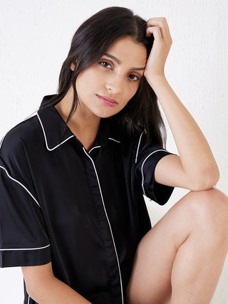 a women giving iconic pose wearing black silky contemporary shorts set made of signature satin