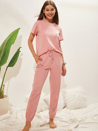 a woman standing on a bed sheet wearing english rose pyjama length dress