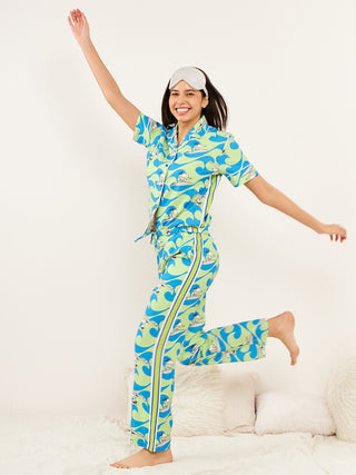 a woman standing against the wall wearing green front open half sleeve pyjama set