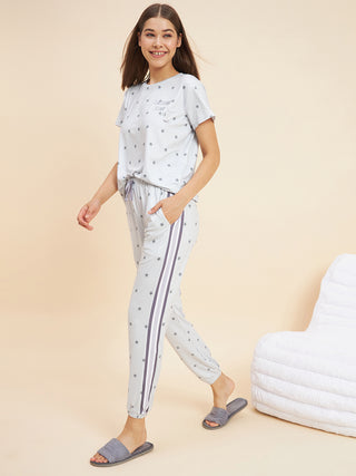 A woman walking and smiling wearing a grey pyjama set