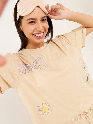 a women with iconic pose holding eye wear wearing sand snoopy starlet pyjama set made of comfy rib